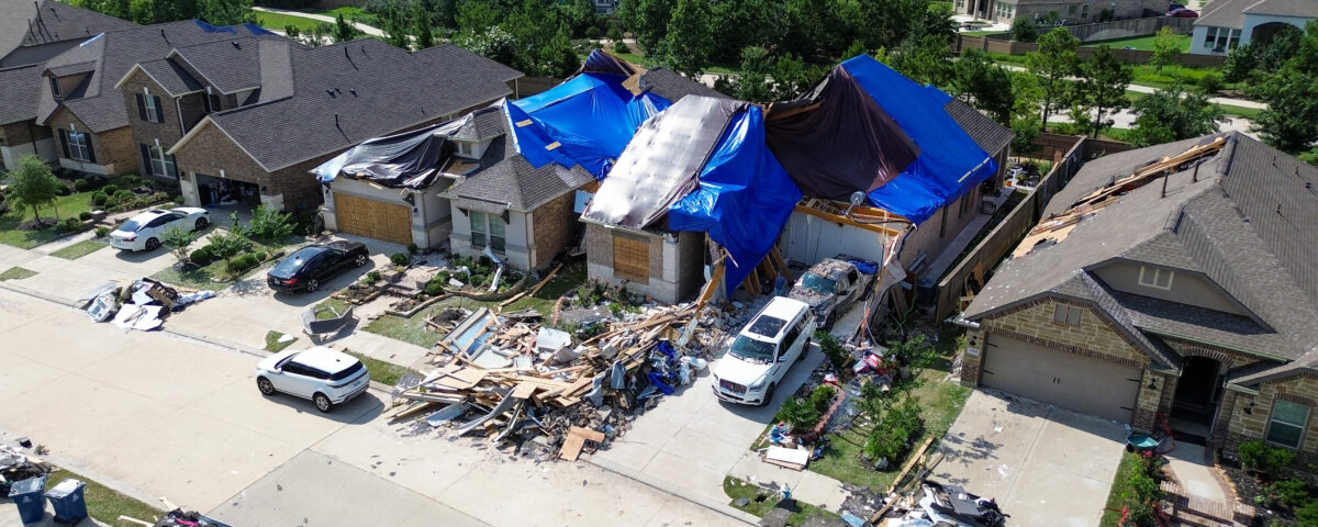 A Florida home with severe hurricane roof damage covered by emergency tarps following a major storm.